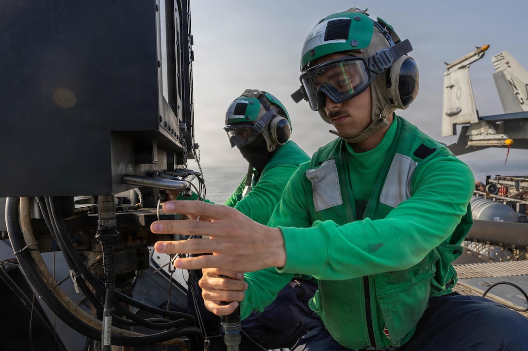 U.S. Navy Electrician’s Mate Fireman Keith Taylor, front, and U.S. Navy Interior Communications Electrician Seaman Brian Reyes prepare work panel assemblies on the flight deck of Nimitz-class aircraft carrier USS Abraham Lincoln (CVN 72), in the Arabian Sea, Feb. 21, 2026. Abraham Lincoln is deployed to the U.S. 5th Fleet area of operations to support maritime security and stability in the Middle East. (U.S. Navy photo by Mass Communication Specialist 3rd Class Samuel Evarts)