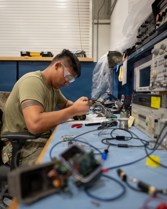 U.S. Air Force Airman 1st Class Elias Aurello, 379th Expeditionary Maintenance Squadron avionics technician, solders wires to an F-16 Fighting Falcon throttle control at Al Udeid Air Base, Qatar, Feb. 18, 2026. Aurello, a participant in Rumble in the Deid, began learning boxing when he arrived to AUAB and has 13 years of Judo experience. (U.S. Air Force photo by Tech. Sgt. Chris Thornbury)