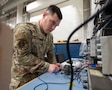 U.S. Air Force Airman 1st Class Brian Witiszin, 379th Expeditionary Maintenance Squadron avionics technician, tests a KC-46 Pegasus actuator at Al Udeid Air Base, Qatar, Feb. 18, 2026. Witiszin checked capacitors, pins and relays of the circuit board for any signs of damage. (U.S. Air Force photo by Tech. Sgt. Chris Thornbury)