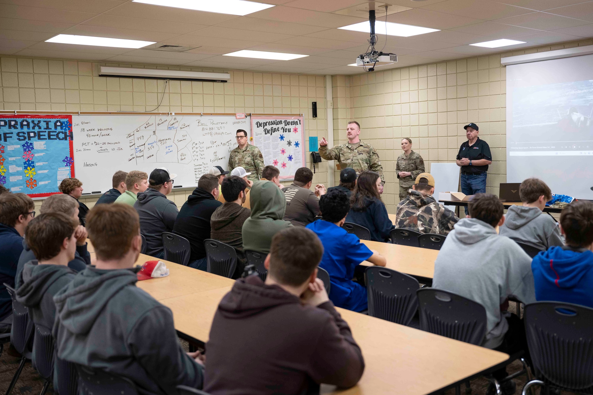 (Left to right) Tech. Sgts. Andrew Lindaman and Joshua Griffith, both recruiters with the 313th Recruiting Squadron; Tech. Sgt. Jamie Gardner, state marketing and advertising noncommissioned officer in charge for the Kansas Joint Force Headquarters and one of the U.S. Air Force’s 2025 Outstanding Airmen of the Year; and Steve Scheuring, owner of Scheuring Speed Sports, talk with students about Air Force career opportunities.