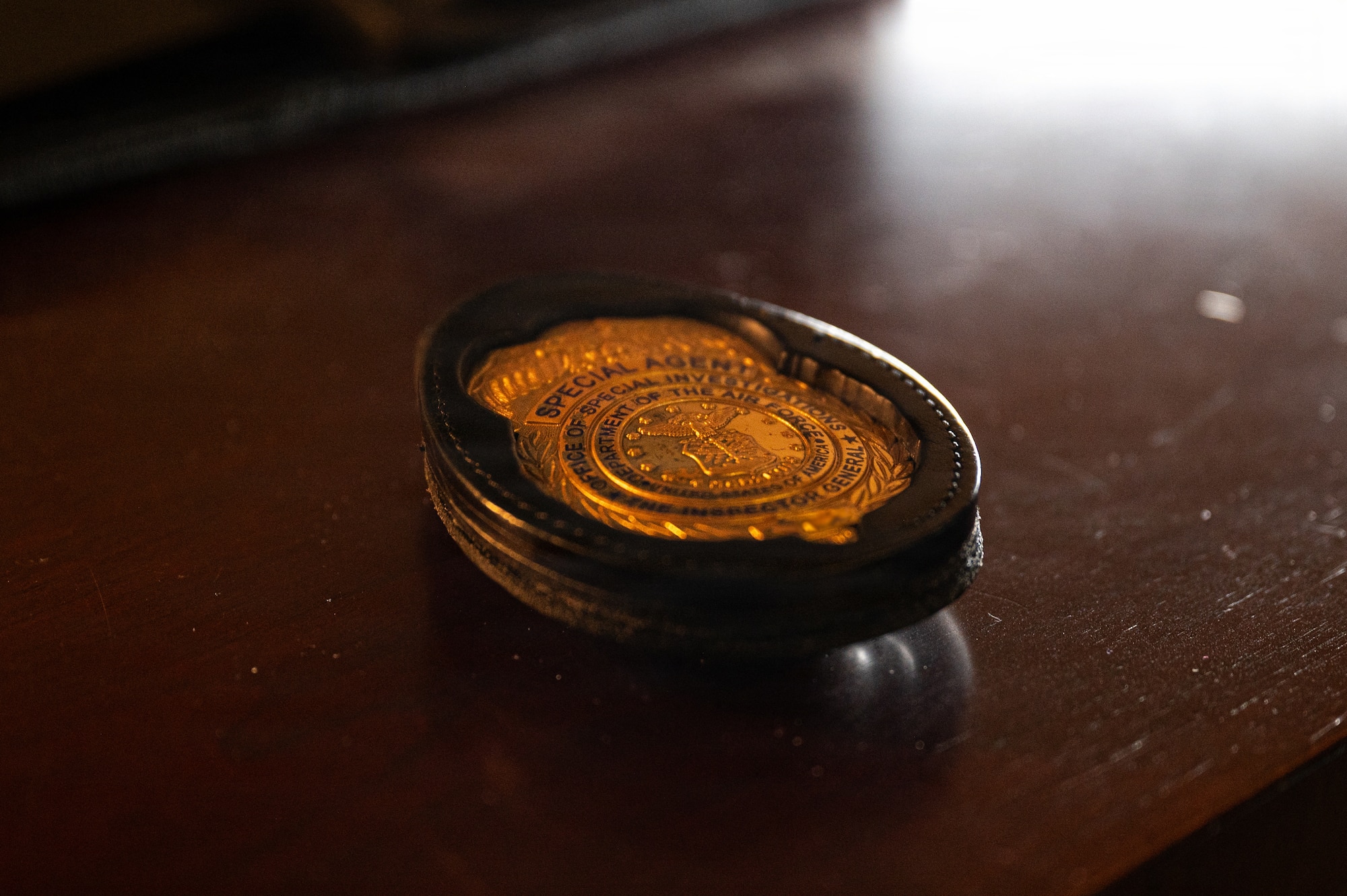 A U.S. Air Force Office of Special Investigations badge is displayed on a desk at Seymour Johnson Air Force Base, North Carolina, Feb. 11, 2026. AFOSI special agents protect Airmen, information and resources by conducting criminal investigations and counterintelligence operations in support of the 4th Fighter Wing mission. (U.S. Air Force photo by Airman 1st Class Holly Leonard)