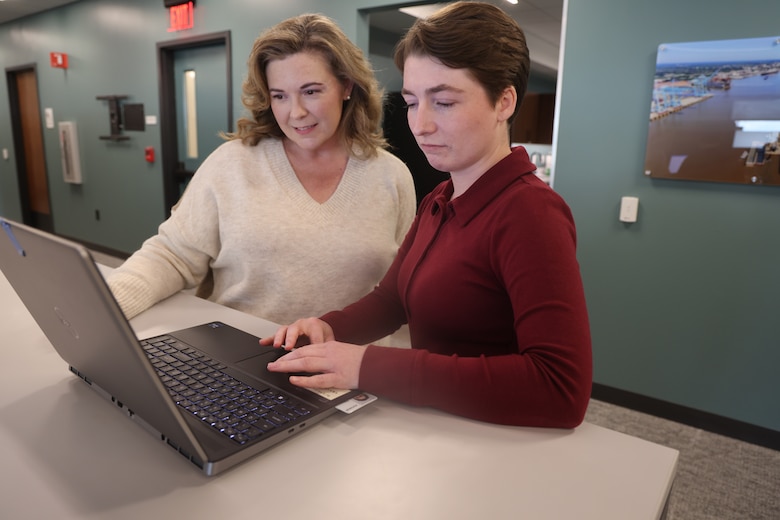Two women working on a computer.