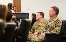 U.S. Air Force Chief Master Sgt. Ricky Lamm, 628th Air Base Wing command chief, and U.S. Navy Capt. Reed Koepp, Naval Support Activity commanding officer, listen to U.S. Air Force Col. Jason Parker, 628th Air Base Wing and Joint Base Charleston commander, speak of his Air Force career during a base visit at Joint Base Charleston.