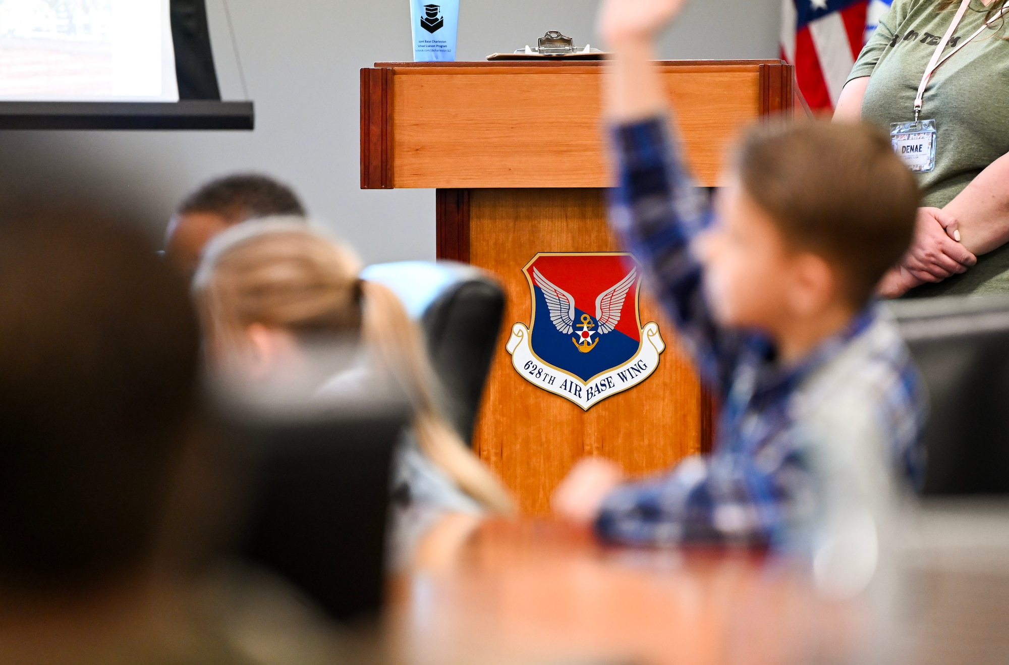Military homeschoolers of the Lowcountry students raise their hands to ask questions regarding naval service during a wing leadership building tour at Joint Base Charleston.