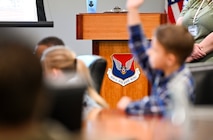 Military homeschoolers of the Lowcountry students raise their hands to ask questions regarding naval service during a wing leadership building tour at Joint Base Charleston.