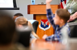 Military homeschoolers of the Lowcountry students raise their hands to ask questions regarding naval service during a wing leadership building tour at Joint Base Charleston.