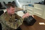 Staff Sgt. Kenneth Fritz adjusts the intercommunication control panel with dial adjuster he manufactured, Portland Air National Guard Base, Oregon, Jan 31, 2026. The dial was used to assist pilots in the cockpit to adjust their intercommunication control panel. Photo by Senior Airman Yuki Klein.