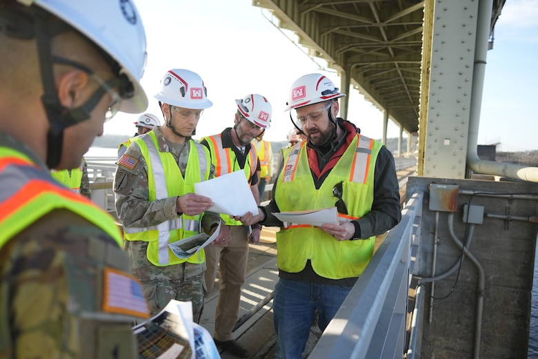 CHATTANOOGA, Tenn. (Feb. 20, 2026) – Ryan Cleary (right), a civil engineer for the U.S. Army Corps of Engineers Nashville District, briefs Col. Herlihy (second from left), commander of the Great Lakes and Ohio River Division, on the installation and welding progress of the miter gates at the Chickamauga Lock Replacement Project in Chattanooga, Tennessee, Feb. 20, 2026. Looking on are Lt. Col. Guillermo Guandique (left), Nashville District commander, and Bob Winters (second from right), a project manager for the lock.