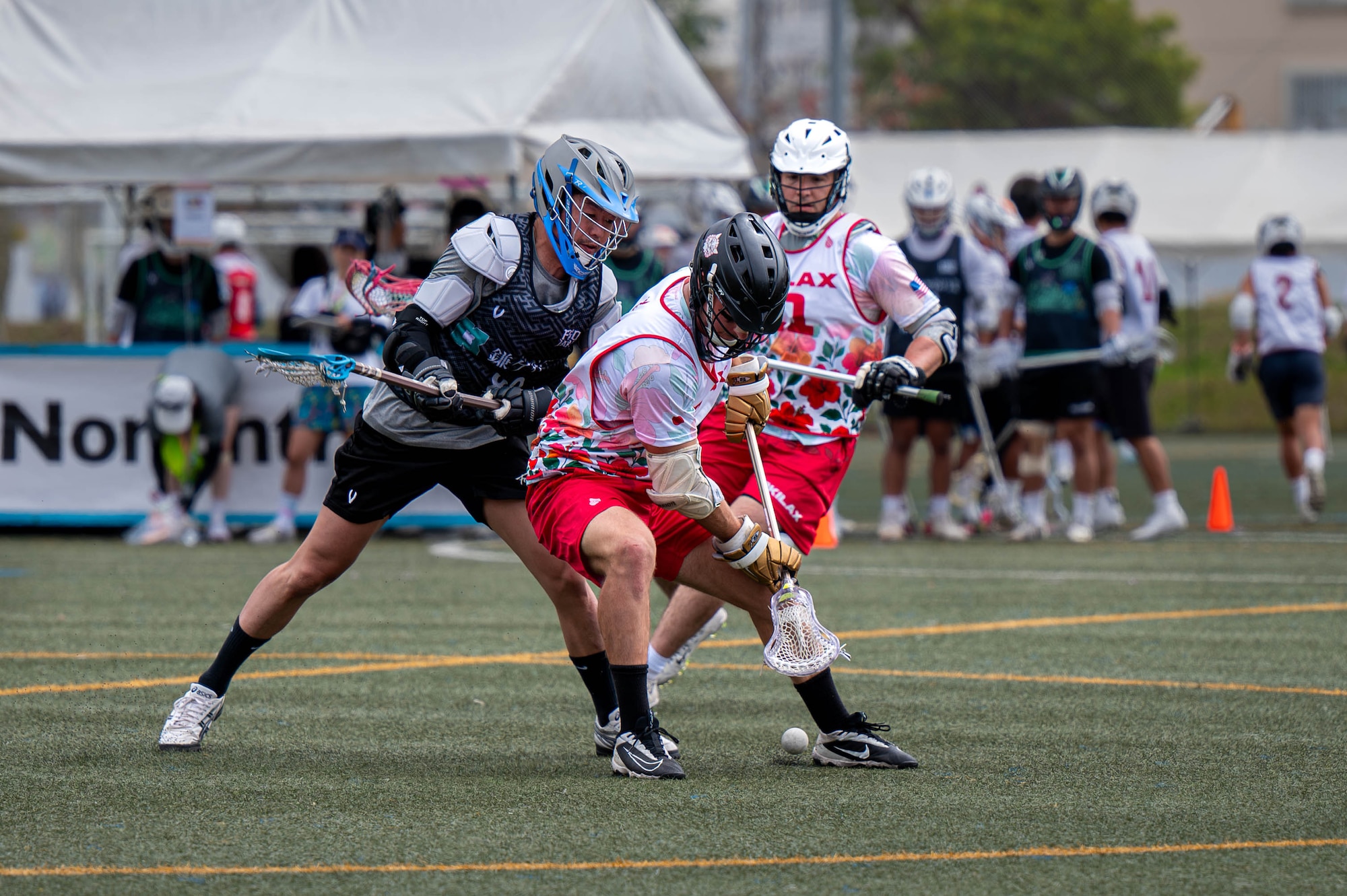 An Okinawa Lacrosse team player fights for possession of the ball during a match against the Kamagaya Gators Lacrosse Club at Shintoshin Park, Japan, Feb. 20, 2026. The OKI LAX team is composed of U.S. service members, civilians, and local community members representing a mix of units, backgrounds and experience levels. (U.S. Air Force photo by Airman 1st Class Nathaniel Jackson)