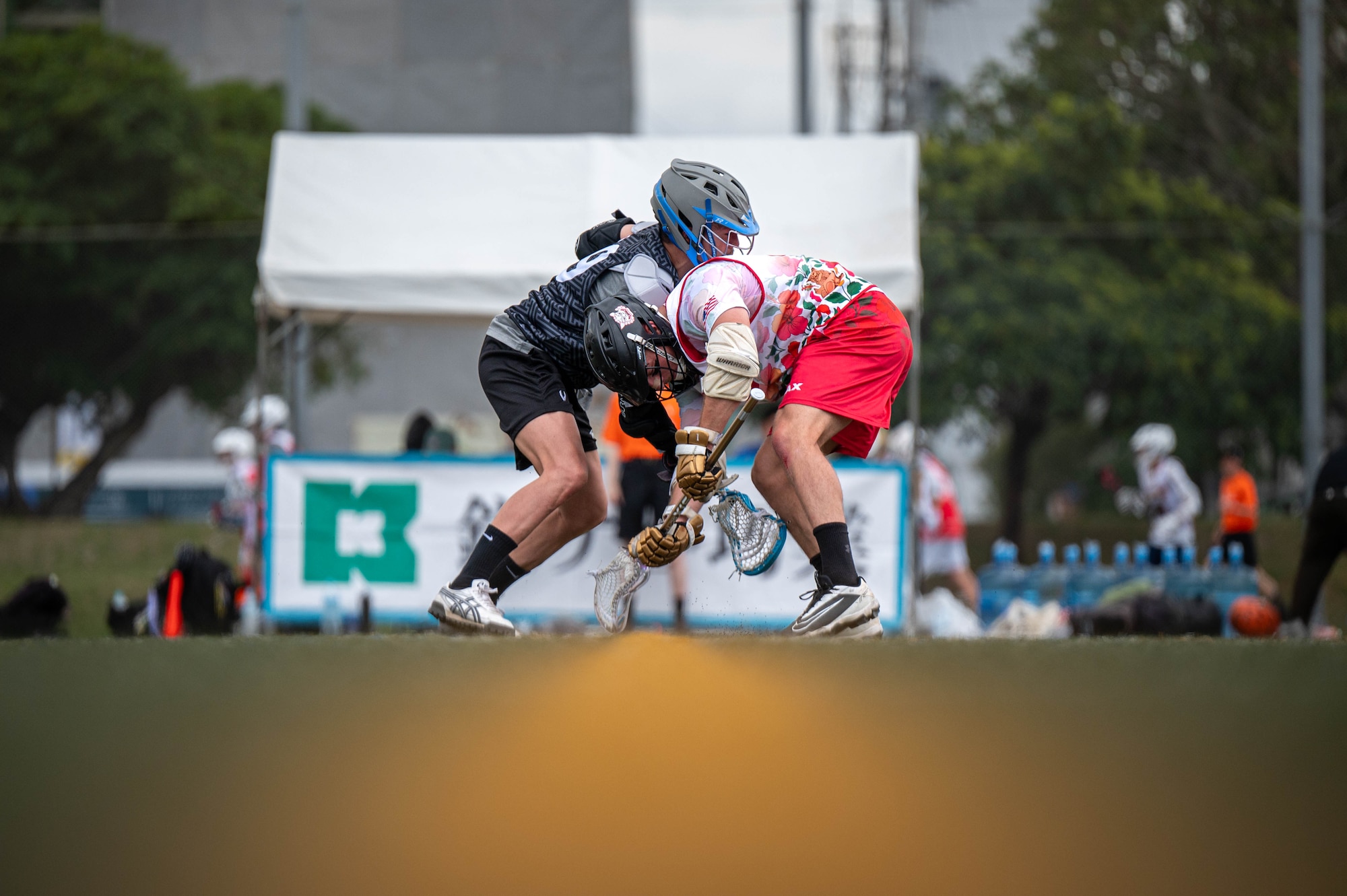 An Okinawa Lacrosse team player  and a Kamagaya Gators Lacrosse Club player  battle for possession of the ball during a lacrosse match at Shintoshin Park, Japan, Feb. 20, 2026. Through friendly competition and shared respect for the game, service members and international partners strengthened relationships beyond the field. (U.S. Air Force photo by Airman 1st Class Nathaniel Jackson)