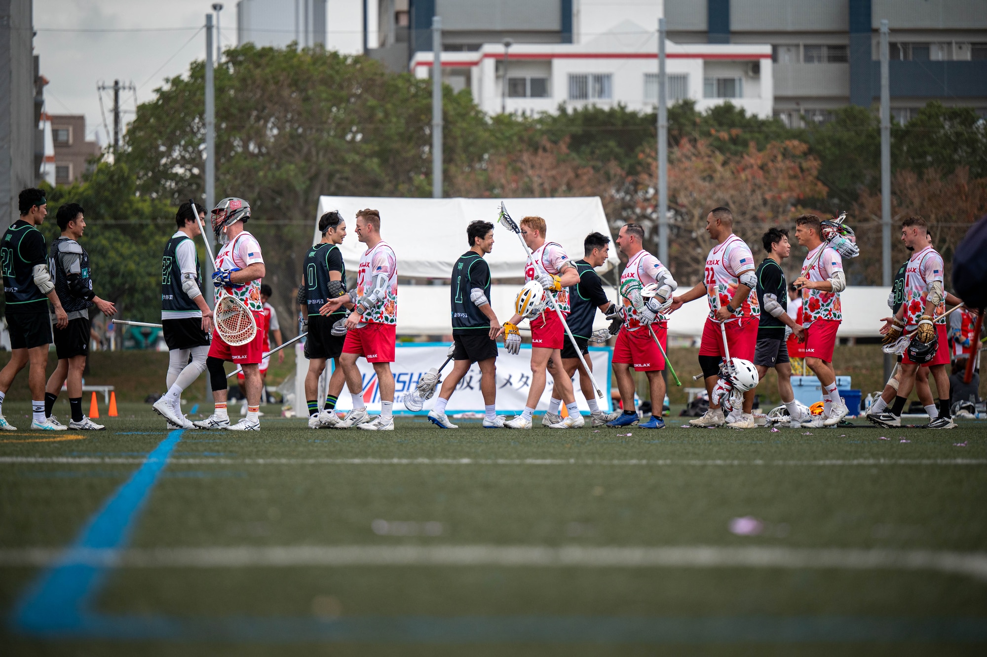 Members of the Okinawa Lacrosse team and the Kamagaya Gators Lacrosse Club exchange post-game handshakes at Shintoshin Park, Japan, Feb. 20, 2026. Through friendly competition and shared respect for the game, service members and international partners strengthened relationships beyond the field and supported continued cooperation across the Indo-Pacific. (U.S. Air Force photo by Airman 1st Class Nathaniel Jackson)