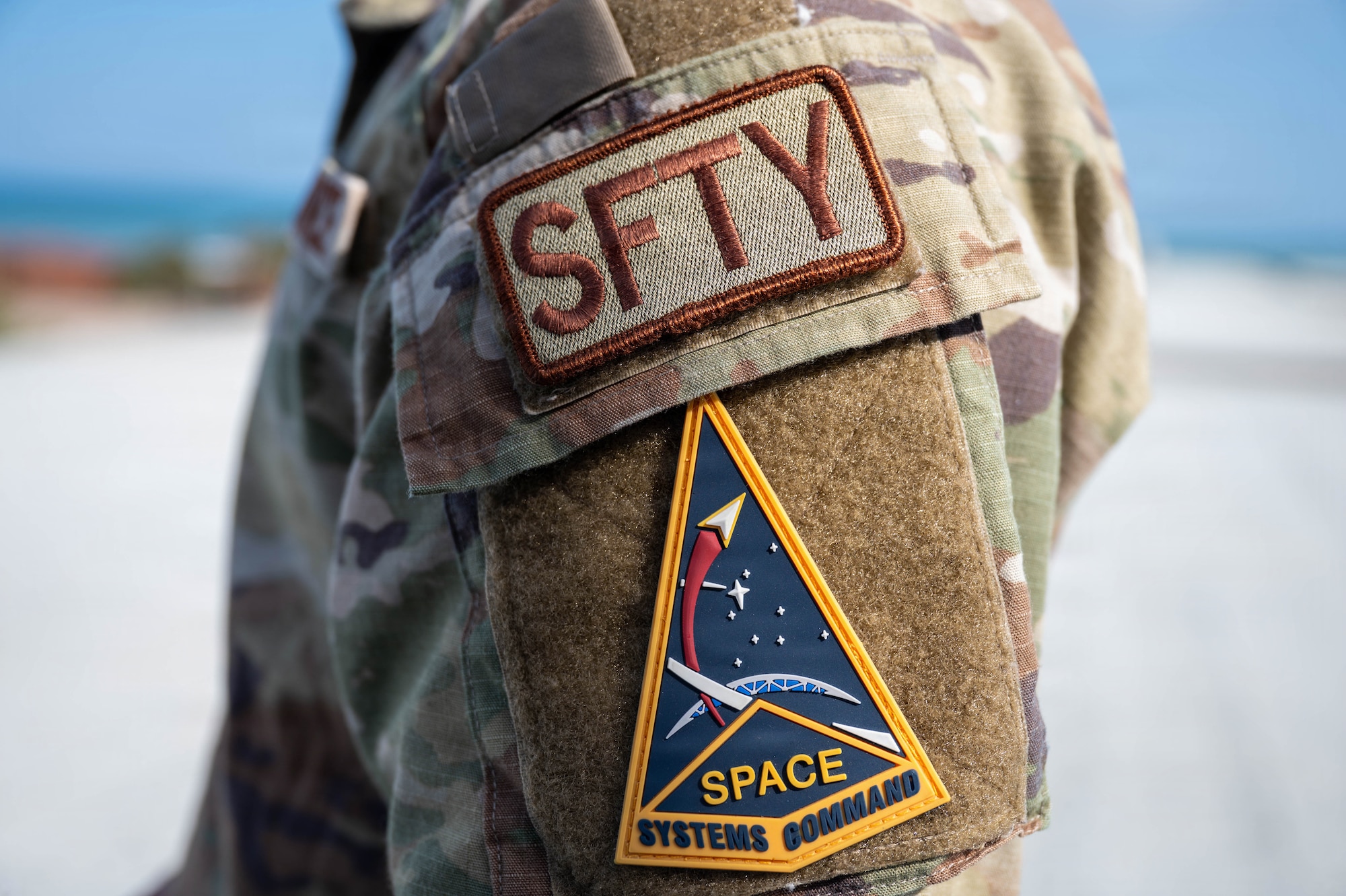 A close-up of the safety identifier patch and Space Systems Command insignia worn by U.S. Air Force Tech. Sgt. Anthony Utreras De Souza, Space Launch Delta 45 noncommissioned officer in charge of occupational safety, at Patrick Space Force Base, Florida, Feb. 19, 2026. Utreras De Souza leads installation occupational safety efforts, ensuring facilities, programs and personnel remain compliant and mission-ready. (U.S. Air Force photo by Staff Sgt. Samuel Becker)
