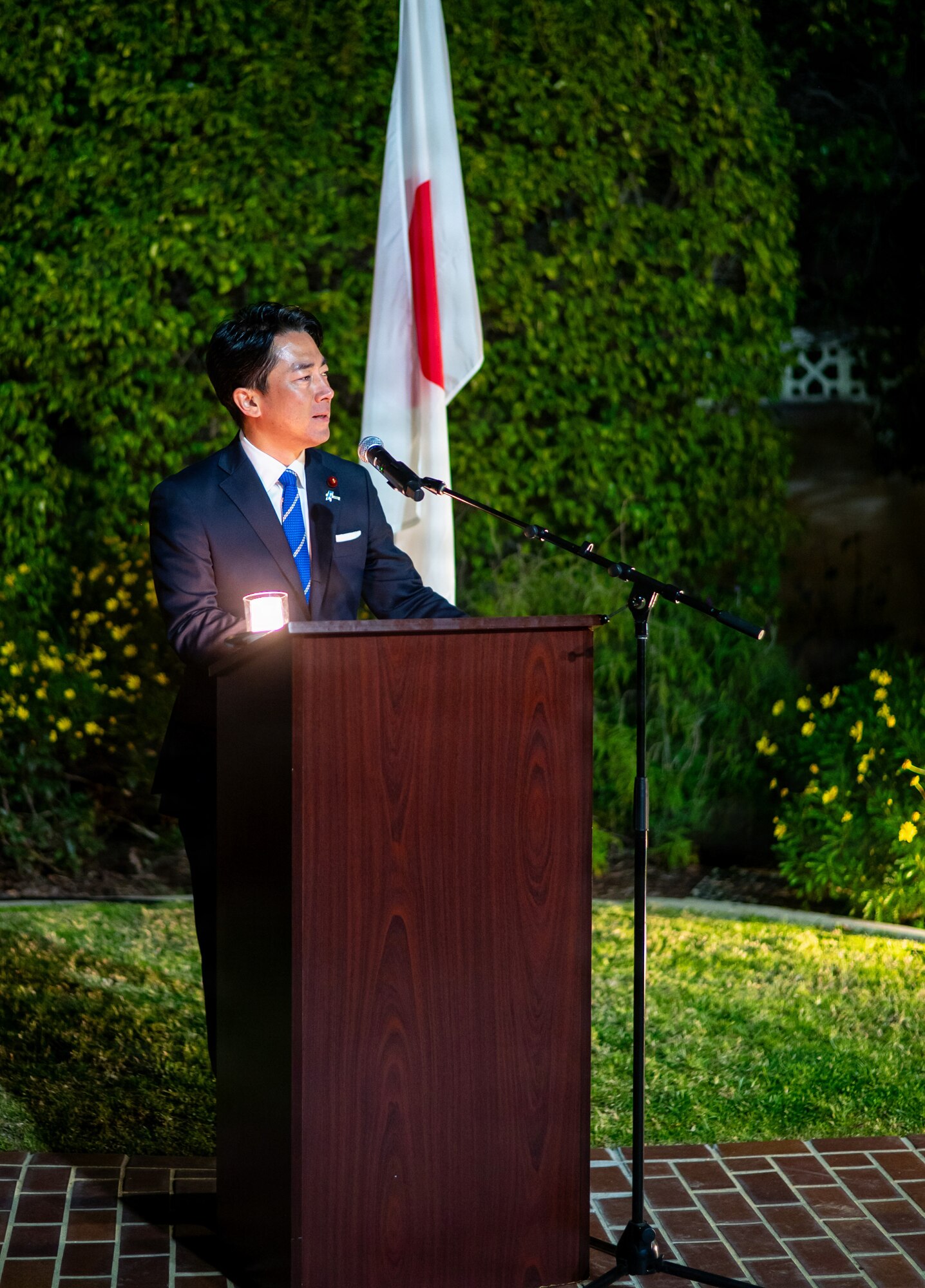 A man stands at a podium, delivering a speech.