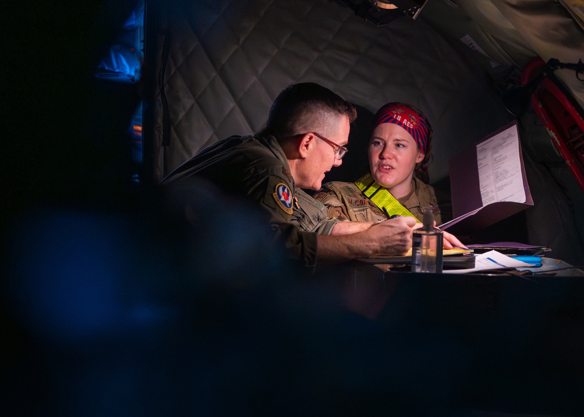 U.S. Air Force Maj. Raymond Kelly, left, and Capt. Dreannan McConnell, both 18th Aeromedical Evacuation Squadron flight nurses, conduct a preflight brief aboard a KC-135 Stratotanker assigned to the 909th Air Refueling Squadron, at Kadena Air Base Japan, Feb. 17, 2026.