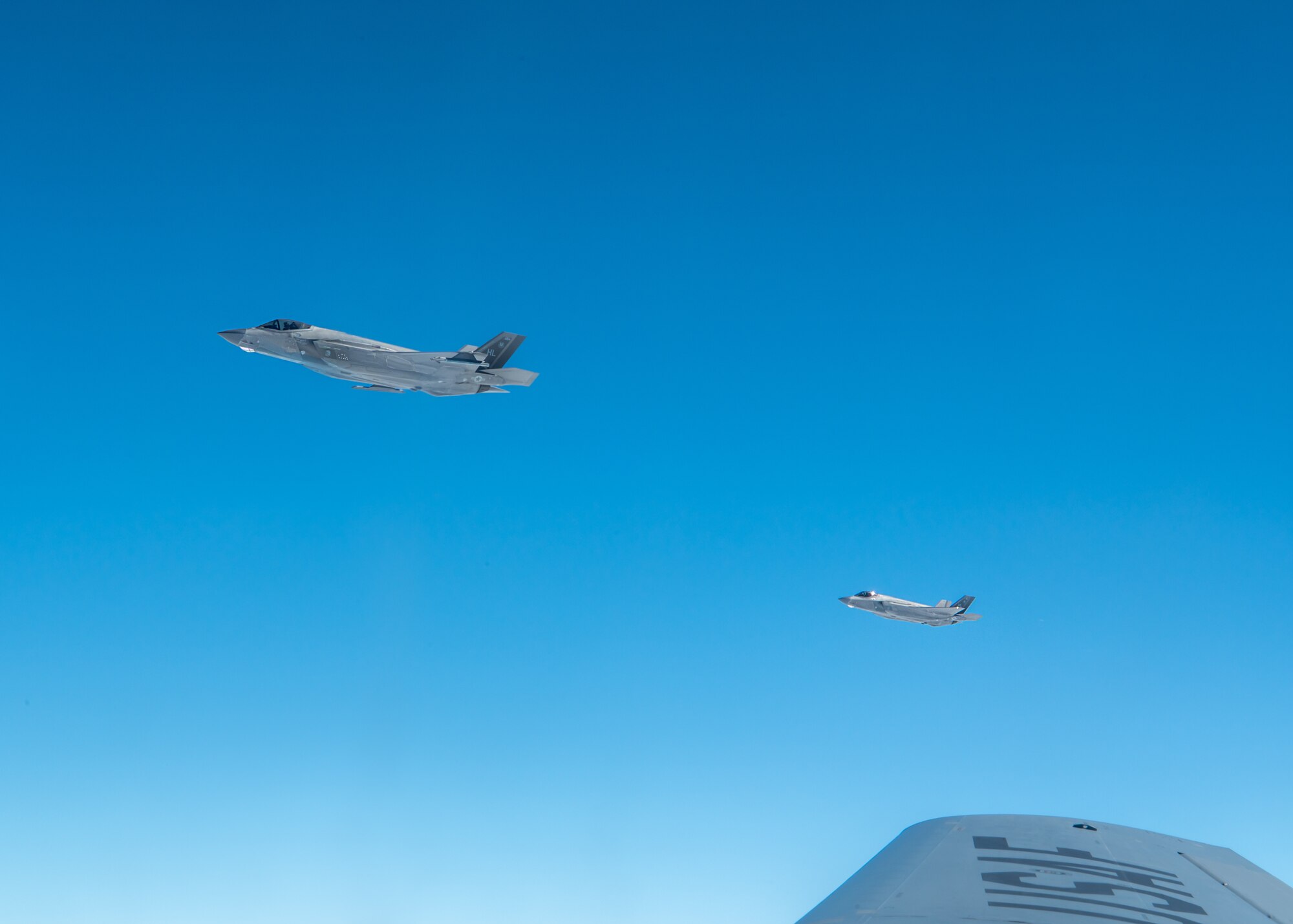Two U.S. Air Force F-35A Lightning II’s, assigned to the 4th Expeditionary Fighter Squadron, deployed to Kadena Air Base, fly in formation with a KC-135 Stratotanker assigned to the 909th Air Refueling Squadron, over the Pacific Ocean, Feb. 17, 2026.
