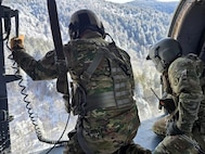 Sgt. Christopher Burke, a Black Hawk crew chief, and Master Sgt. Tracy Banta, a flight paramedic with the Tennessee Army National Guard, begin hoisting an injured hiker with severe cold weather injuries into a hovering UH-60 Black Hawk helicopter in the Great Smoky Mountains National Park, Feb. 24, 2026.