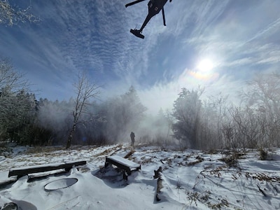 Sgt. 1st Class Nolan Ogle, a flight paramedic with the Tennessee Army National Guard, prepares an injured hiker with severe cold weather injuries to be hoisted into a hovering UH-60 Black Hawk helicopter in the Great Smoky Mountains National Park, Feb. 24, 2026.