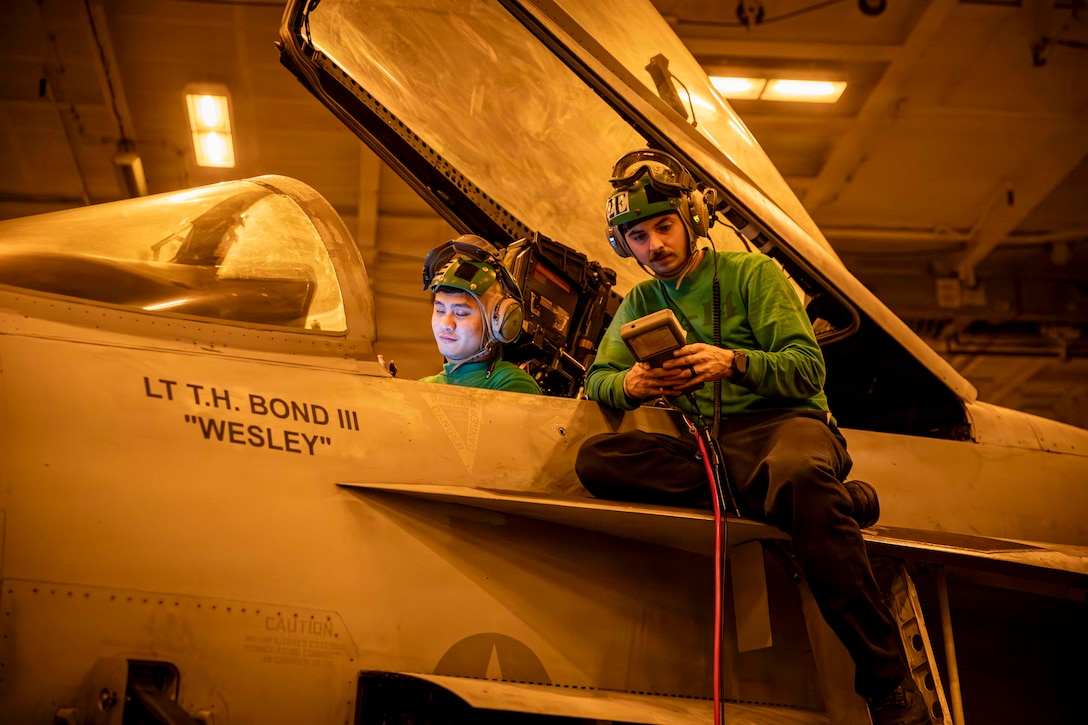 U.S. Navy Aviation Electrician’s Mate 2nd Class Kent Cadelina, left, and U.S. Navy Aviation Electrician’s Mate 3rd Class Steven Souders conduct maintenance on an F/A-18E Super Hornet, attached to Strike Fighter Squadron (VFA) 14, in the hangar bay aboard Nimitz-class aircraft carrier USS Abraham Lincoln (CVN 72), in the Arabian Sea, Feb. 23, 2026. Abraham Lincoln is deployed to the U.S. 5th Fleet area of operations to support maritime security and stability in the Middle East. (U.S. Navy photo by Mass Communication Specialist Seaman Aljay Monzales)