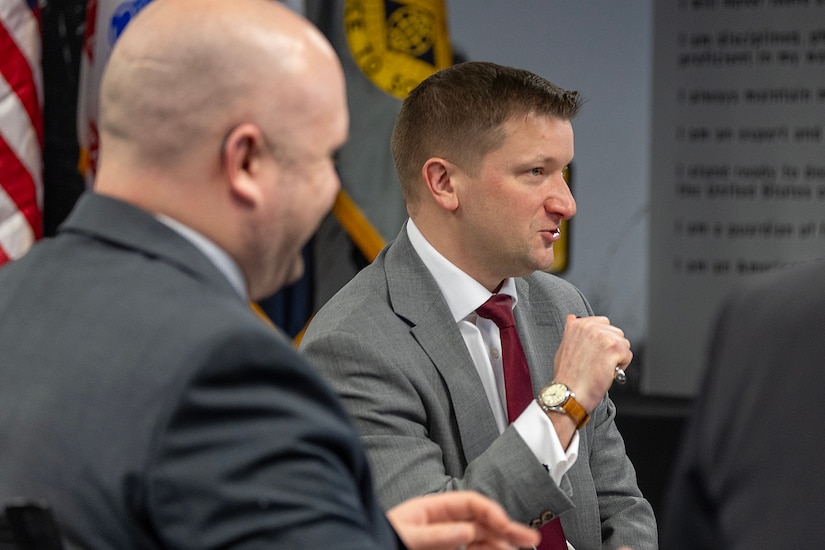 Jules W. Hurst III, senior official performing the duties of the Under Secretary of War (Comptroller) and chief financial officer, center, makes remarks as Art Miller, Deputy Comptroller for OUSW(C) Budget and Appropriations Affairs, smiles during a meeting with the U.S. Army Financial Management Command at the Maj. Gen. Emmett J. Bean Federal Center in Indianapolis Feb. 23, 2026. During the meeting, USAFMCOM provided a high-level overview of the two-star command’s mission support to the U.S. Army Materiel Command as well as its direct support to ASA (FM&C), outlining enterprise-level capabilities and authorities across the Army financial management portfolio, including Reserve Component integration. (U.S. Army photo by Mark R. W. Orders-Woempner)