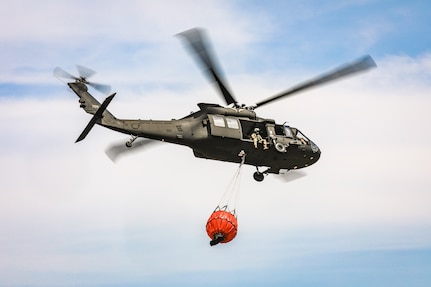 An Oklahoma Army National Guard UH-60 Black Hawk flies over the 702 Fire in Blaine County, Oklahoma after dropping more than 600 gallons of water on the fire, July 16, 2022.