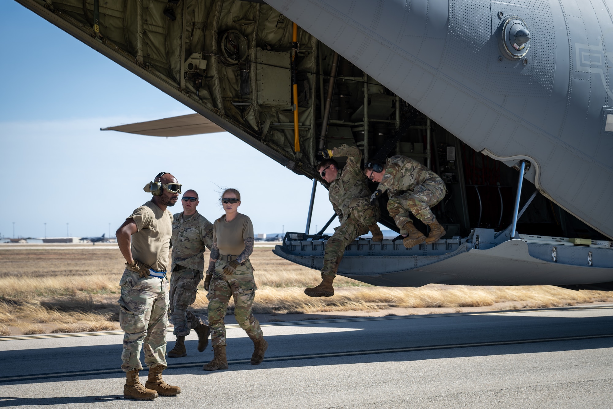 U.S. Airmen assigned to the 21st Combat Air Base Squadron climb off the ramp of a C-130J Super Hercules assigned to the 317th Airlift Wing after a landing zone operation training during exercise  Bamboo Eagle 26-1 at Dyess Air Force Base, Texas, Feb. 18, 2026. BE 26-1 reinforced the skills needed for the 21st CABS to deliver Agile Combat Employment in austere locations. (U.S. Air Force photo by Airman 1st Class Adrien Tran)