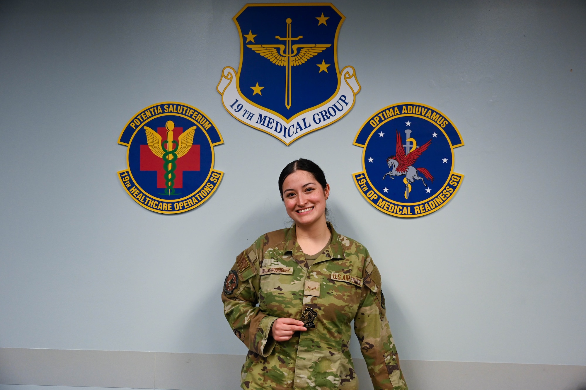 Woman poses in front of wall.