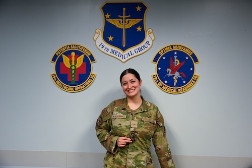 Woman poses in front of wall.