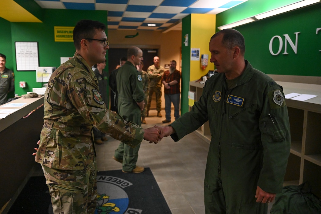 Two men shake hands.