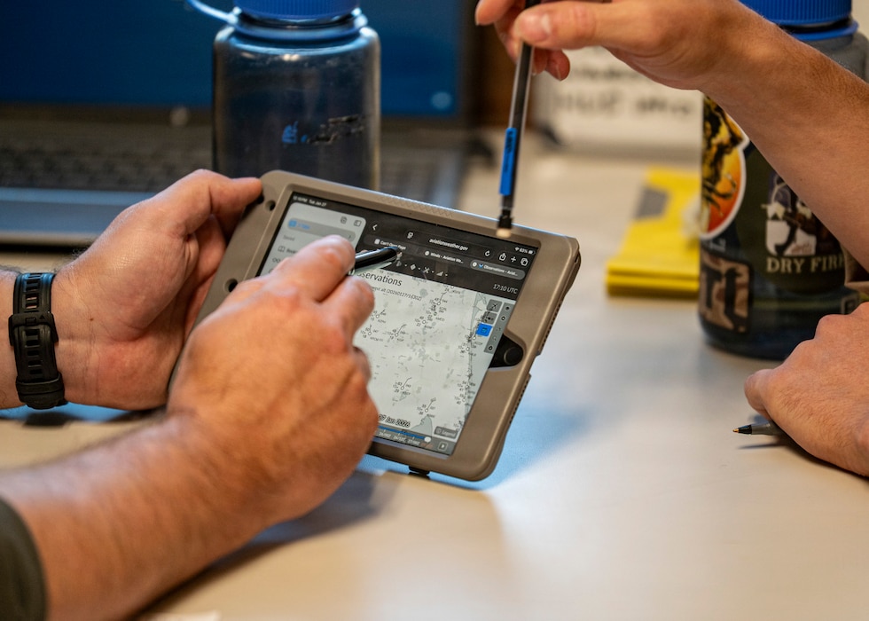U.S. Coast Guard Lt. James Cozby, Training Air Wing (TW-5) FIVE instructor pilot, left, and U.S. Marine Corps 2nd Lt. Alex Hardin, student naval aviator assigned to the “Shooters” Training Squadron (VT) 6, go over details of their upcoming flight at Avon Park Air Force Range, Florida, Jan. 27, 2026. Students trained in the T-6B Texan II as part of the early phase of undergraduate naval flight training. (U.S. Air Force photo by Senior Airman Leonid Soubbotine)