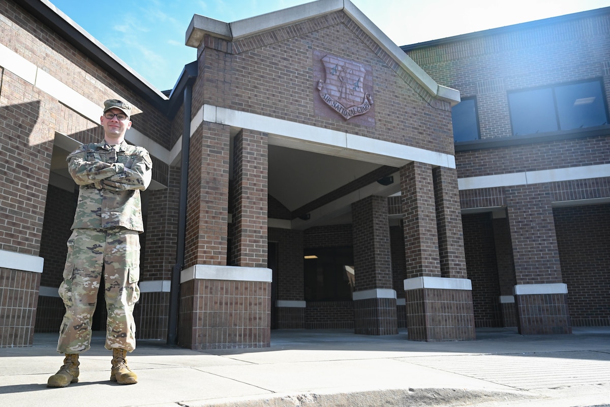 Man poses in front of a building.