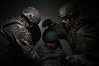 up photo of air force Airmen providing tactical combat casualty care to a simulated victim