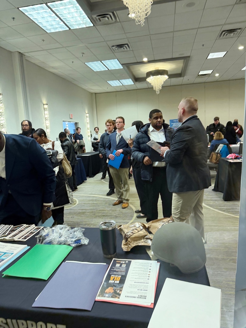 Photo shows a group of people standing in a conference room.