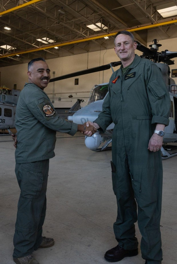 U.S. Marine Corps Gunnery Sgt. Jose Espitia, a flightline mechanic with Marine Light Attack Helicopter Squadron (HMLA) 775, Marine Aircraft Group 41, 4th Marine Aircraft Wing, receives a challenge coin from Brig. Gen. Patrick Tiernan, commanding general of 4th Marine Air Wing, after a successful operational training at Marine Corps Air Station, Camp Pendleton, California, Jan. 29, 2026. As the lead of an aircraft recovery effort, Espitia was responsible for organizing and supervising significant maintenance evolutions at an unfamiliar airfield, meanwhile selflessly mentoring junior and senior maintainers. (U.S. Marine Corps photo by Lance Cpl. Allan Rodriguez-Rivera