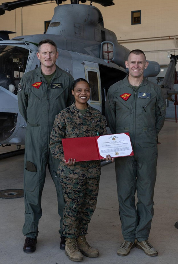 Hospital Corpsman 1st Class Wanda Sangalang, a corpsman with Marine Aircraft Group 41, 4th Marine Air Wing, poses with Brig. Gen. Patrick Tiernan, commanding general of 4th Marine Air Wing and Sgt. Maj. Joshua Miller, command senior enlisted leader of 4th Marine Air Wing, after receiving her end of tour Navy and Marine Corps Commendation Medal at Marine Corps Air Station, Camp Pendleton, California, Jan. 29, 2026. HM1 Sangalang served as the medical senior enlisted leader, demonstrating exceptional performance that contributed to medical readiness and administrative processing of all medical requirements across the squadron. (U.S. Marine Corps photo by Lance Cpl. Allan Rodriguez-Rivera)