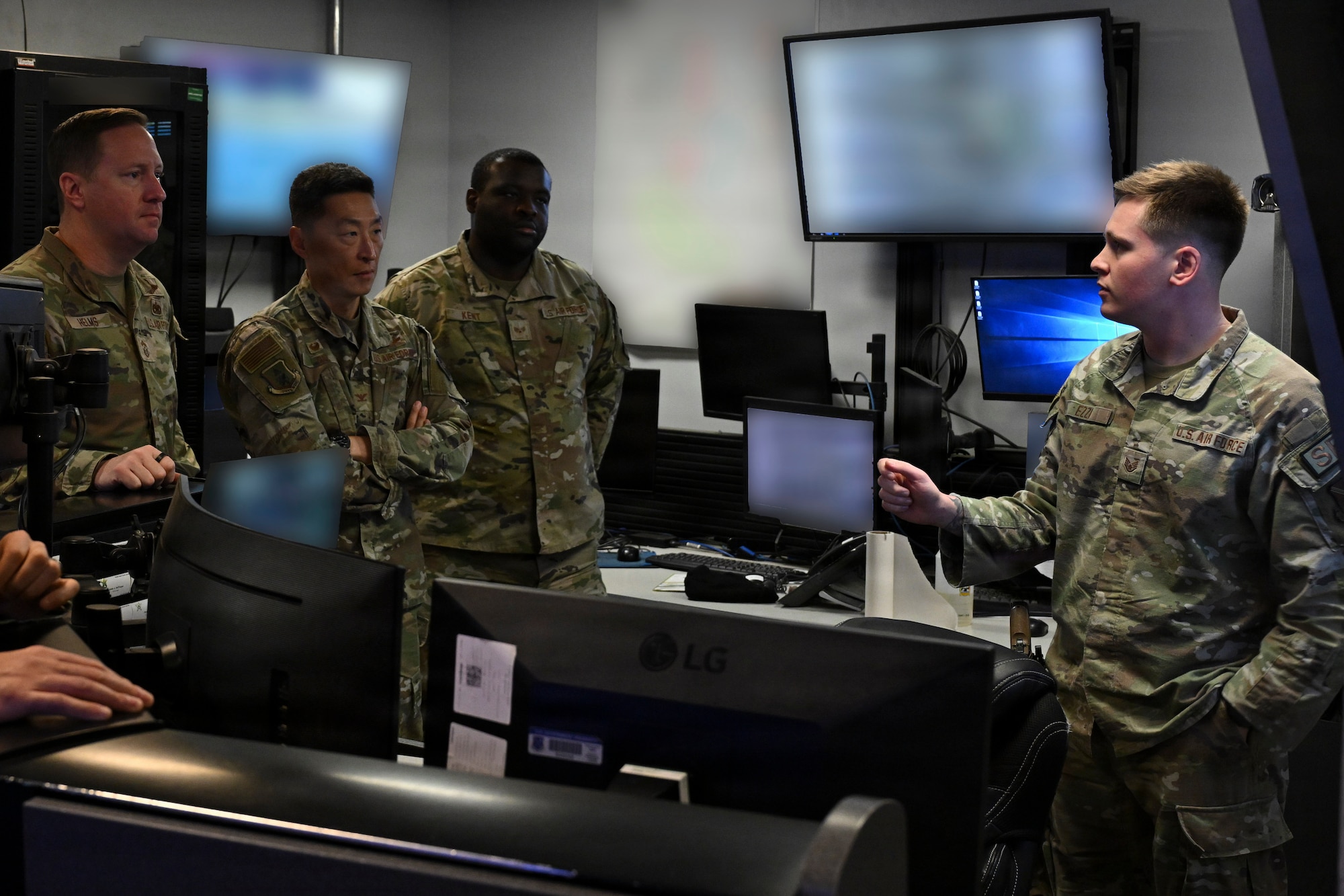 U.S. Air Force Staff Sgt. Joel A. Ezzi, 316th Security Forces Squadron Base Defense Operations Center controller, explains his duties to Col. Jun S. Oh, 316th Wing and installation commander, and Chief Master Sgt. Kevin W. Helms, 316th Wing command chief, during the February “Winnin’ Like a Griffin” recognition at Joint Base Andrews, Maryland, Feb. 17, 2026. Ezzi was recognized for leading training and readiness programs within his flight and serving as the squadron’s lead BDOC controller during the wing combat readiness inspection and the installation’s largest airshow in decades.