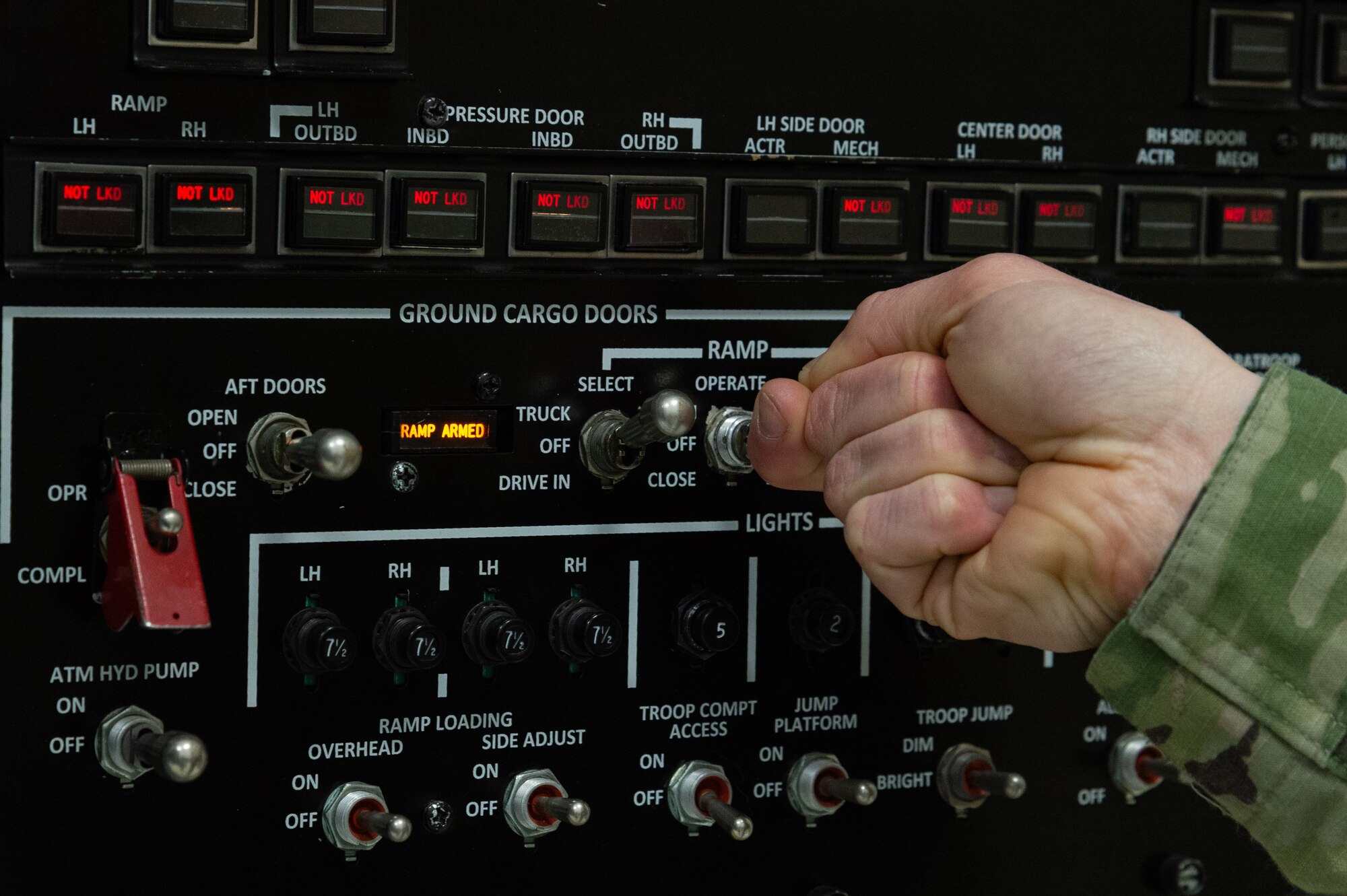 U.S. Air Force Tech. Sgt. Ashleigh Norris, 436th Maintenance Group Maintenance Qualification Training Program hydraulics instructor, operates the C-5 aft ramp maintenance training device located at the 373rd Training Squadron, Detachment 3 on Dover Air Force Base, Delaware, Feb. 12, 2026. Norris described key hydraulic components and ramp operation as she held the switch on the control panel. (U.S. Air Force photo by Roland Balik)