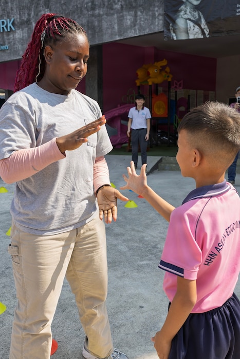 PATTAYA, Thailand — Civilian mariner Jalen Douglas, 3rd Mate, assigned to expeditionary fast transport ship USNS City of Bismarck (T-EPF 9), interacts with a student during a community outreach event at the Learning Center of the Human Help Network Foundation in Pattaya, Thailand, Jan. 27, 2026. (Photo by Grady T. Fontana)