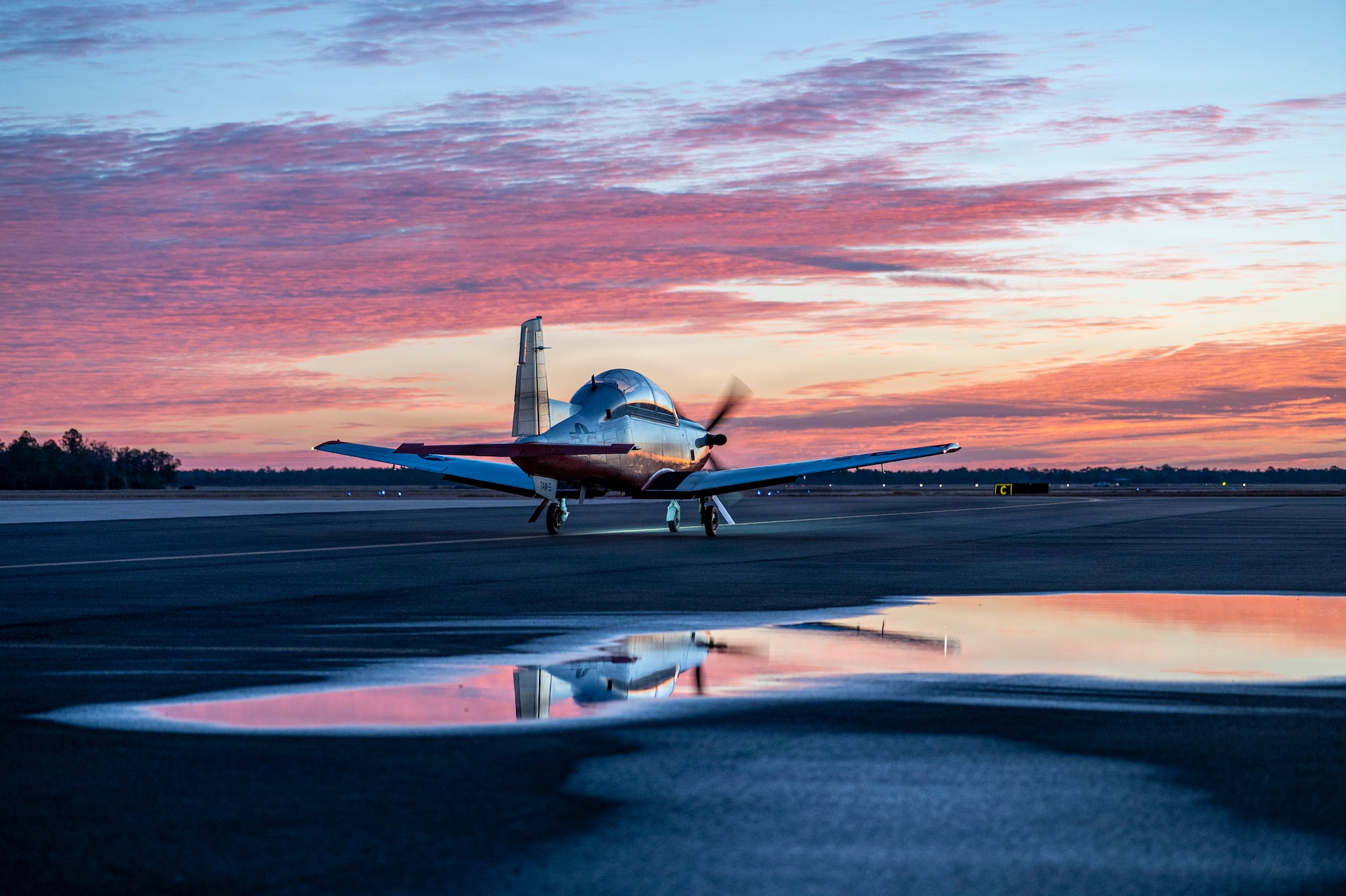 A U.S. Navy T-6B Texan II taxies down a runway at Avon Park Air Force Range, Florida, Jan. 27, 2026. 23 T-6B Texan II, 46 instructors and 86 students traveled to Avon Park AFR for joint primary aviation training (U.S. Air Force photo by Senior Airman Leonid Soubbotine)