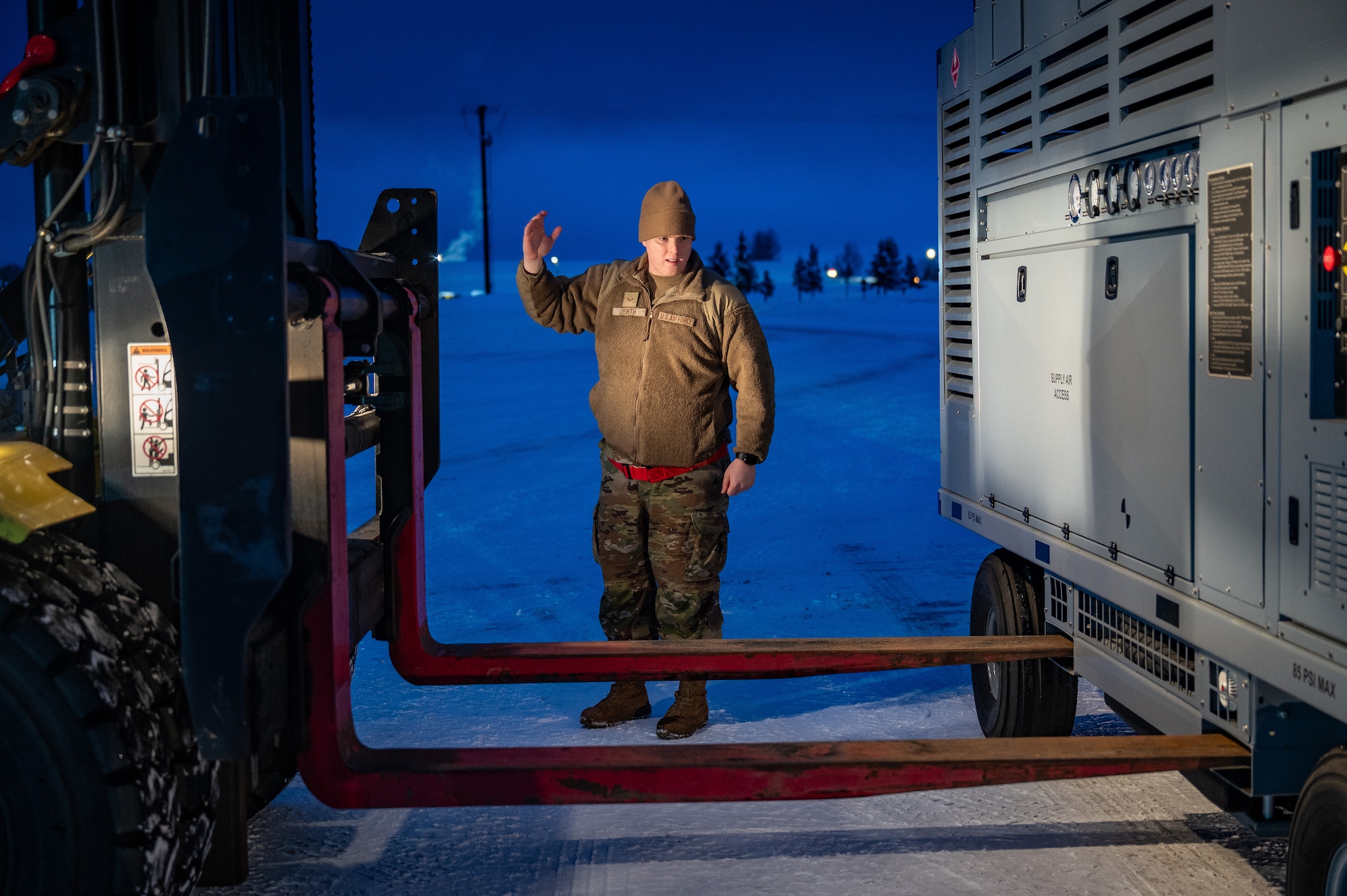 U.S. Air Force Senior Airman Jakob Smith, 773d Logistics Readiness Squadron ground transportation support operator, guides a forklift during a Prepositioned Warfighting Materiel movement at Joint Base Elmendorf-Richardson, Alaska, Jan. 15, 2026. The movement of PWM revamps Pacific Air Command's ability to rapidly generate airpower and provides the theater with enhanced infrastructure, robust material maintenance, and advanced command, control, communications, computers, and intelligence capabilities. (U.S. Air Force photo by Senior Airman Hunter Hites)