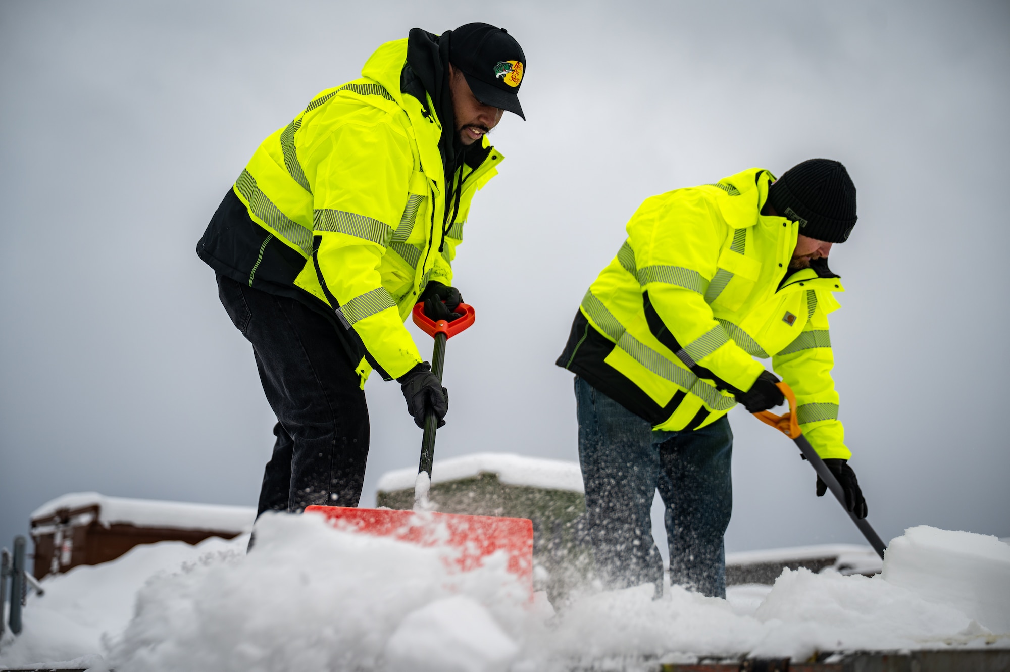 673d Logistics Readiness Squadron contractors, Xavier Strong, left, and Matt Regevig, clear snow from a trailer in order to load Prepositioned Warfighting Materiel at Joint Base Elmendorf-Richardson, Alaska, Jan. 15, 2026. The movement of PWM revamps Pacific Air Command's ability to rapidly generate airpower and provides the theater with enhanced infrastructure, robust material maintenance, and advanced command, control, communications, computers, and intelligence capabilities. (U.S. Air Force photo by Senior Airman Hunter Hites)