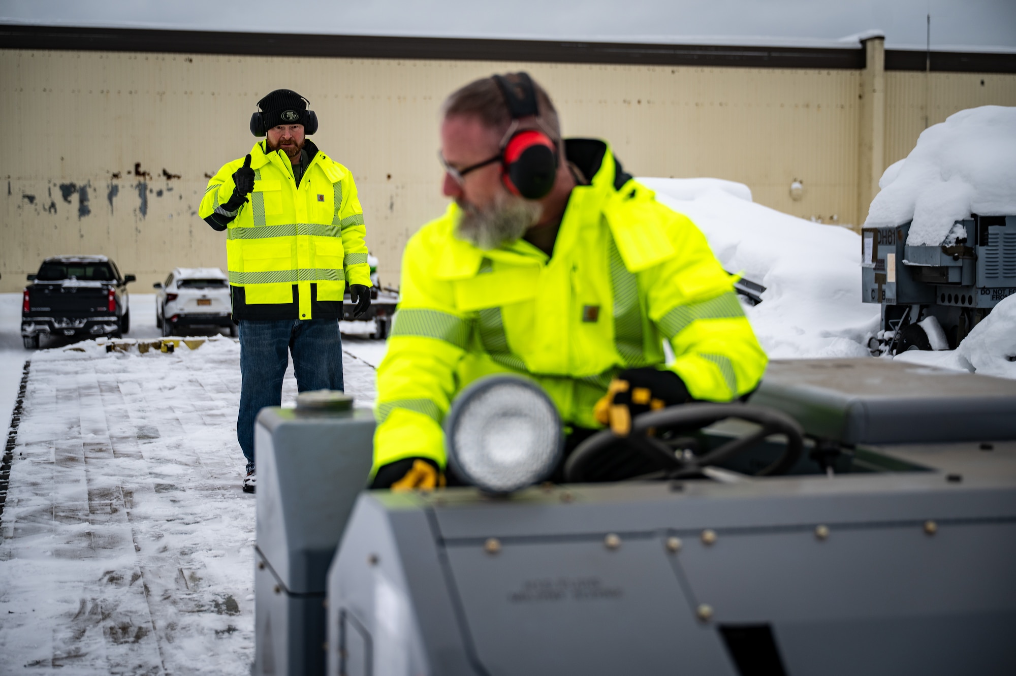 Matt Regevig, left, and Matt Davis, 673d Logistics Readiness Squadron contractors, load Prepositioned Warfighting Materiel onto a trailer at Joint Base Elmendorf-Richardson, Alaska, Jan. 15, 2026. The materiel consists of rapidly deployable equipment sets that enable facility establishment, communications, and aircraft sortie generation in austere environments, thereby reducing the need for long-distance airlift of supplies. (U.S. Air Force photo by Senior Airman Hunter Hites)
