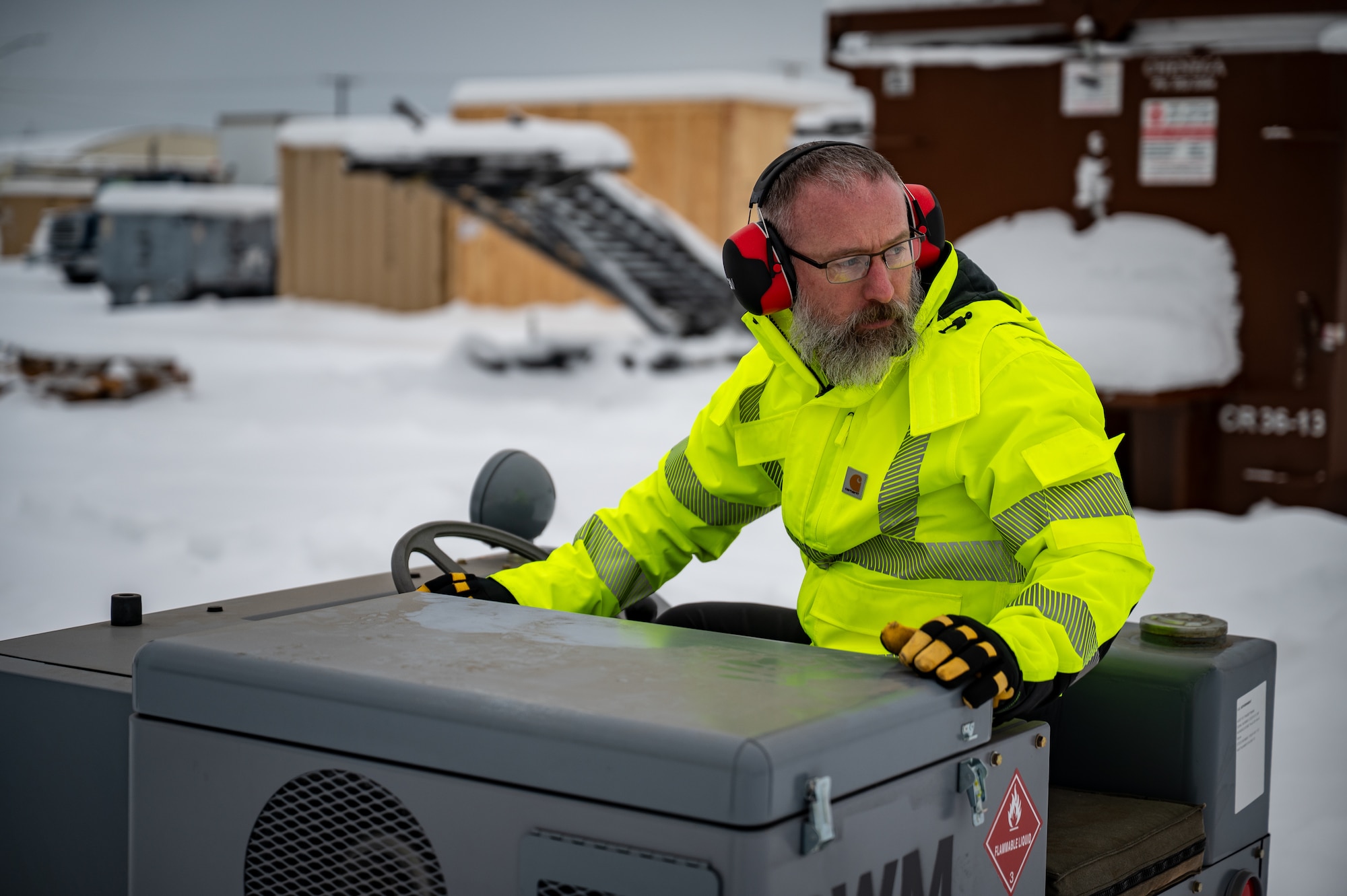 Matt Davis, 673d Logistics Readiness Squadron contractor, loads Prepositioned Warfighting Materiel onto a trailer at Joint Base Elmendorf-Richardson, Alaska, Jan. 15, 2026. The materiel consists of rapidly deployable equipment sets that enable facility establishment, communications, and aircraft sortie generation in austere environments, thereby reducing the need for long-distance airlift of supplies. (U.S. Air Force photo by Senior Airman Hunter Hites)