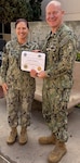 U.S. Navy Lt. Cmdr. Chad Laughrey, a chaplain at Naval Medical Center San Diego, accompanied by U.S. Navy Capt. Elizabeth Adriano, NMCSD director, displays his board certification from the National Association of Veterans Affairs Chaplains at NMCSD, Feb. 17. Board-certified chaplains complete rigorous training in both the classroom and the clinical setting to meet professional standards of clinical chaplaincy. NMCSD employs more than 5,000 active-duty military personnel, civilians, and contractors in Southern California to deliver exceptional care afloat and ashore. (U.S. Navy photo via courtesy asset)