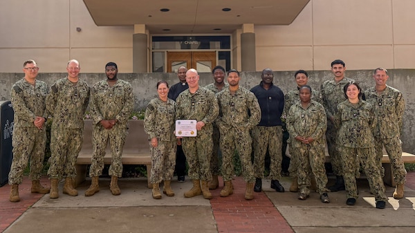 U.S. Navy Lt. Cmdr. Chad Laughrey, a chaplain at Naval Medical Center San Diego, displays his board certification from the National Association of Veterans Affairs Chaplains, surrounded by NMCSD Director U.S. Navy Capt. Elizabeth Adriano and members of the religious programs team at NMCSD, Feb. 17. As a board-certified chaplain, Laughrey now enhances NMCSD with his expertise as a member of the pastoral care services department. NMCSD employs more than 5,000 active-duty military personnel, civilians, and contractors in Southern California to deliver exceptional care afloat and ashore. (U.S. Navy photo via courtesy asset)