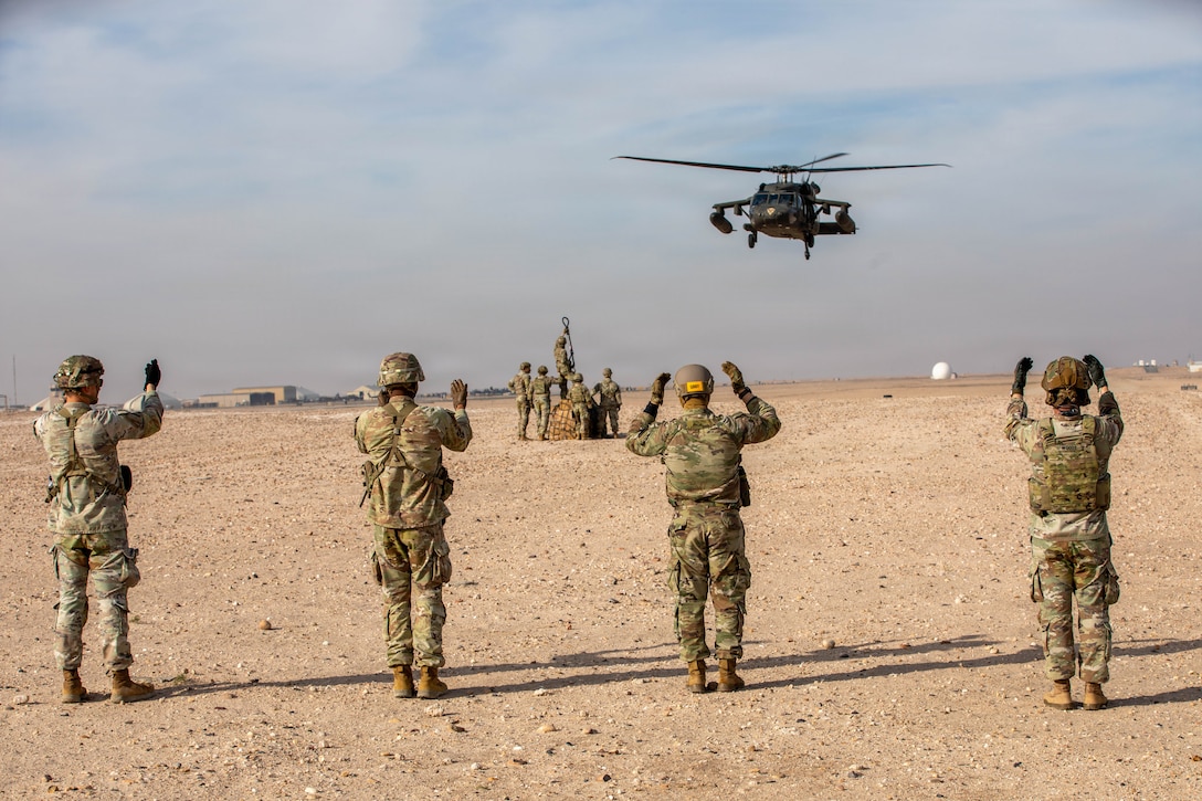Soldiers assigned to U.S. Army Central guide in a UH-60 Blackhawk for landing using hand and arm signals during a Pathfinder School field training exercise in the U.S. Central Command area of responsibility, Jan. 27, 2026. Pathfinder School trains Soldiers on aircraft orientation and helicopter landing zone operations, close combat assault, ground-to-air communication procedures, and sling-load operations. (U.S. Army photo by Capt. Bernard Jenkins)