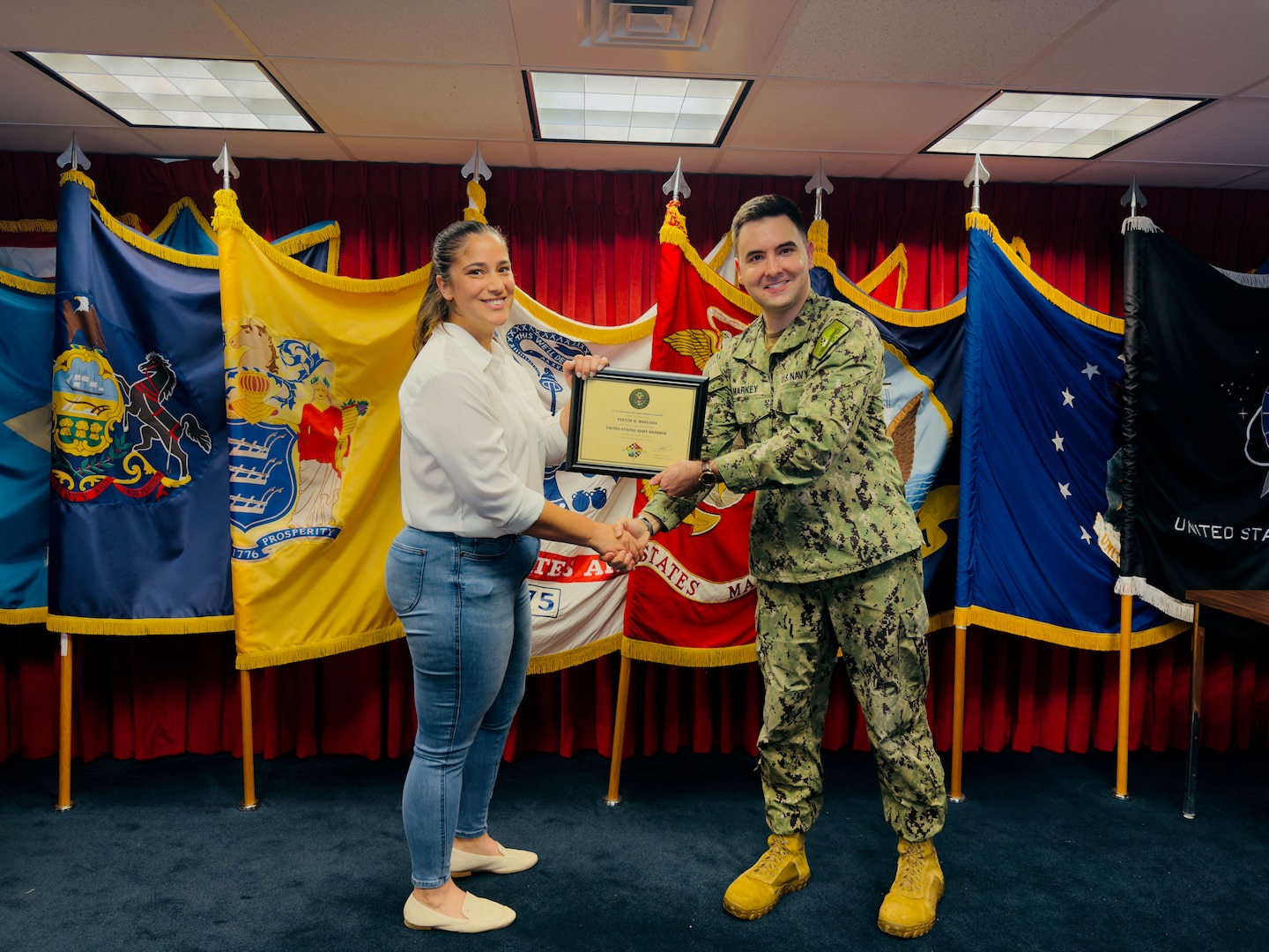 (L) Yvette Meeches, Fort Dix MEPS lead human resources assistant, shakes hands with Navy Lt. Seamus Markey, Fort Dix MEPS executive officer, after taking the oath of enlistment. Meeches joined the Army Reserve as a 38B, civil affairs specialist and will continue to support the MEPS after initial entry training.