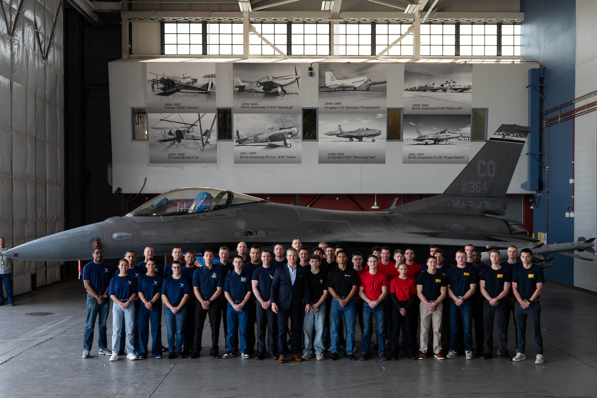 The Honorable Secretary of War, Pete Hegseth, poses with enlistees after administering the Oath of Enlistment to 40 Americans and honored top recruiters while visiting Colorado, Feb 23, 2026, Buckley Space Force Base, Colorado. Sister Services across the Air Force Reserve Command, National Guard, U.S. Army, U.S. Marine Corps, and U.S. Navy answered the Department of War’s call to support the mass enlistment. (DoW photo by U.S. Air Force Staff Sgt. Madelyn Keech)