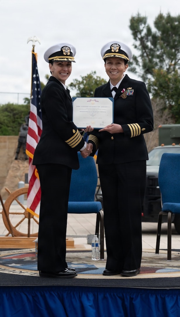 Navy Capt. Virginia Damin, commanding officer, Navy Medicine Readiness and Training Command Camp Pendleton and director, Naval Hospital Camp Pendleton, presents Capt. Cheri Smiley, outgoing executive officer and incoming commanding officer of Expeditionary Medical Facility 150 Alpha with the Meritorious Service Medal in recognition of her outstanding service throughout her time as the executive officer during the EMF 150 Alpha change of command ceremony aboard NHCP on Feb. 20, 2026.