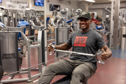 Man exercises on gym equipment.