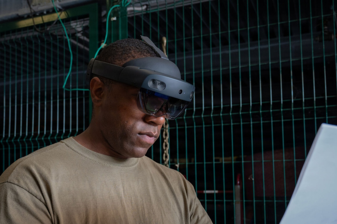 A close-up view of a man in a brown T-shirt looking through a headset.